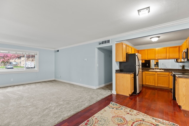 kitchen with visible vents, ornamental molding, dark wood-type flooring, a sink, and appliances with stainless steel finishes