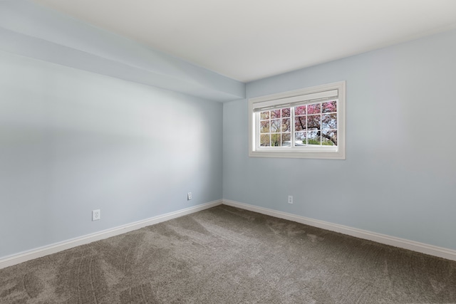 empty room featuring carpet flooring and baseboards