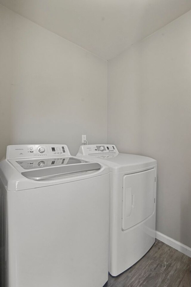 laundry room with baseboards, laundry area, dark wood-type flooring, and washer and clothes dryer
