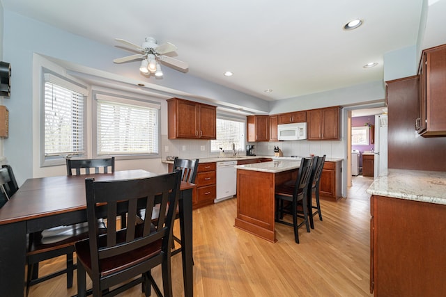 5635 Stanhope St, West Bloomfield, MI 48322 - kitchen with a kitchen island, a breakfast bar, white appliances, ceiling fan, and light wood-type flooring