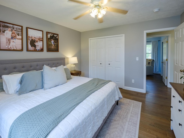 bedroom featuring dark wood-type flooring, baseboards, ceiling fan, and a closet