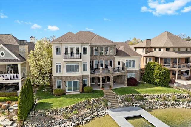 rear view of house featuring a yard, stairway, a residential view, and a balcony
