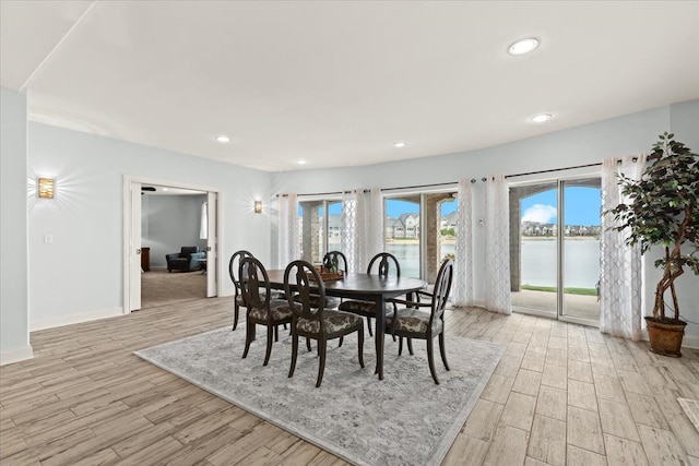 dining room featuring light wood finished floors, baseboards, and recessed lighting