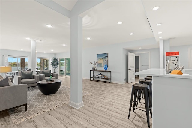 living room with baseboards, light wood-type flooring, and recessed lighting