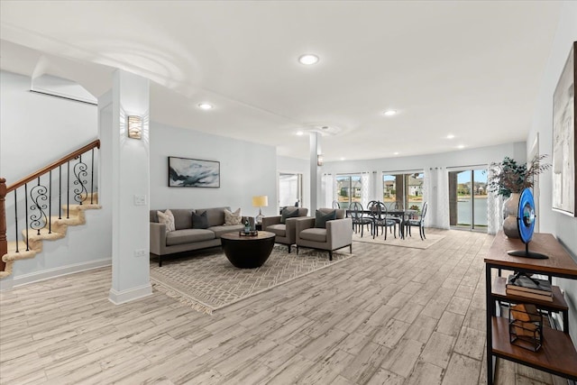 living area with stairs, wood finished floors, ornate columns, recessed lighting, and baseboards