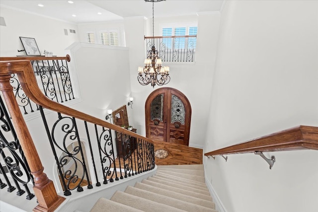 staircase featuring crown molding, a chandelier, baseboards, and recessed lighting