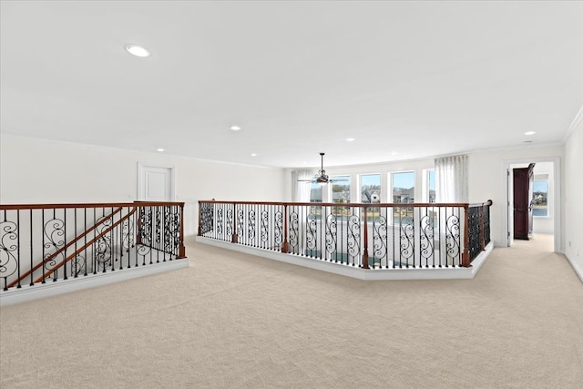 corridor with light colored carpet, an upstairs landing, ornamental molding, and recessed lighting
