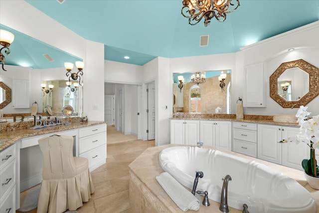 bathroom featuring visible vents, a bath, vanity, a chandelier, and a high ceiling