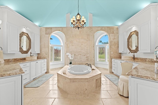 bathroom with a chandelier, lofted ceiling, a bath, and plenty of natural light
