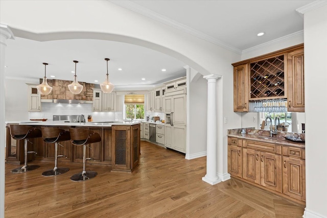 bar with a sink, arched walkways, ornate columns, and dishwasher
