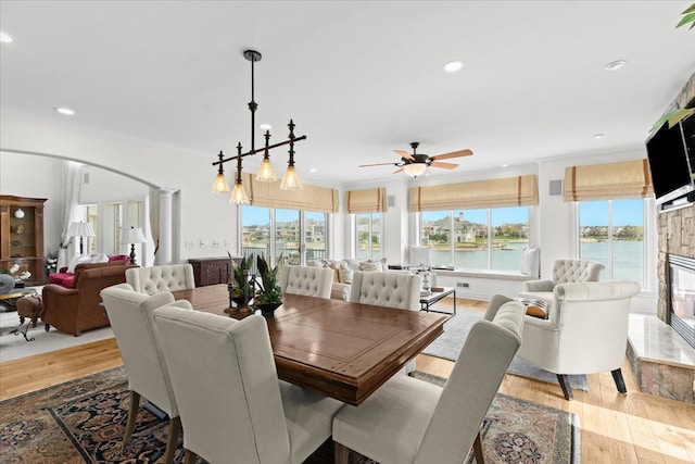 dining space with ceiling fan, crown molding, plenty of natural light, and arched walkways