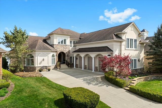 view of front facade with concrete driveway, stucco siding, a front lawn, and stone siding