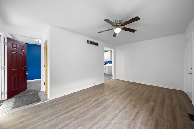 unfurnished living room with baseboards, ceiling fan, visible vents, and wood finished floors