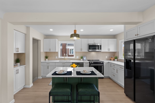 23130 Beverly St, Saint Clair Shores, MI 48082 - kitchen with black appliances, a sink, light countertops, decorative backsplash, and recessed lighting