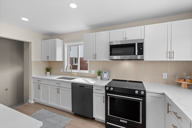 23130 Beverly St, Saint Clair Shores, MI 48082 - kitchen with stainless steel microwave, dishwasher, black range with electric stovetop, a sink, and white cabinets