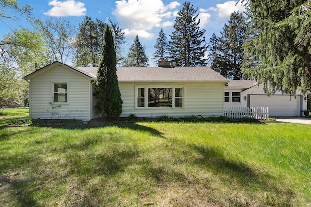 ranch-style home with a chimney, a front yard, and a garage