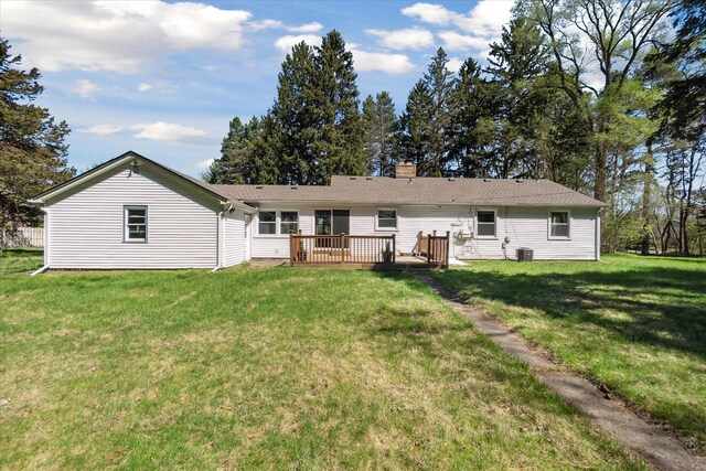 back of property featuring central air condition unit, a wooden deck, a yard, and a chimney
