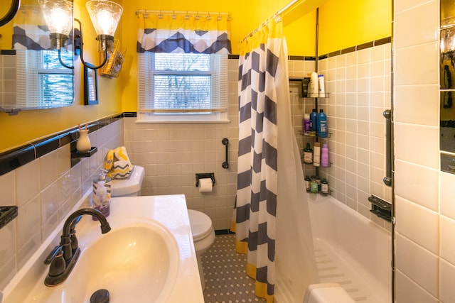 bathroom featuring tile walls, tile patterned flooring, a sink, toilet, and a shower with shower curtain