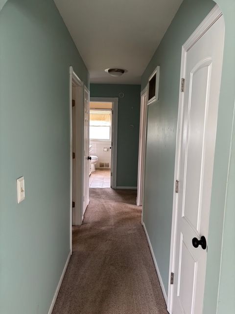 hallway with baseboards and carpet