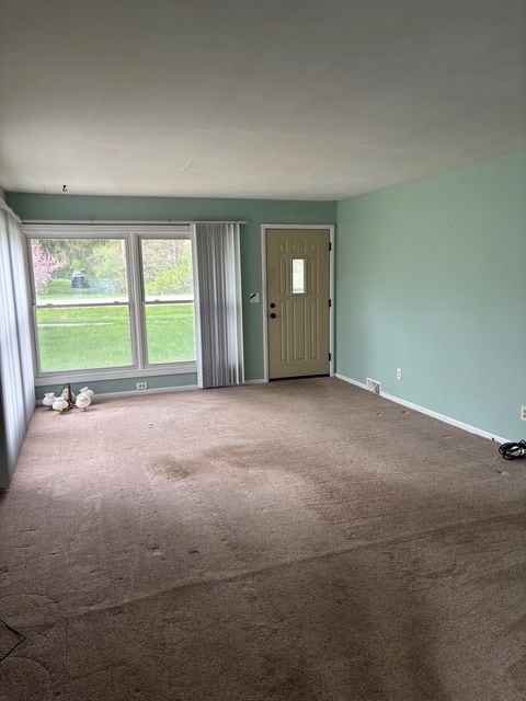 interior space with baseboards and carpet