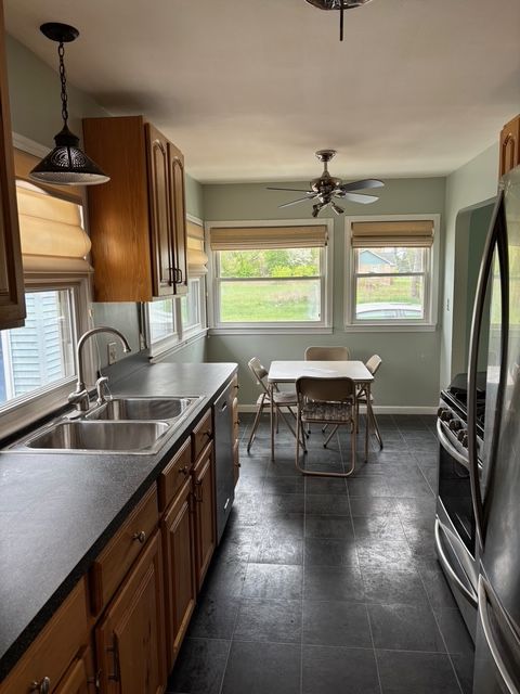 kitchen featuring a sink, appliances with stainless steel finishes, baseboards, and a wealth of natural light