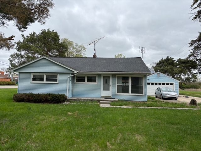 view of front of home featuring a front lawn and a detached garage