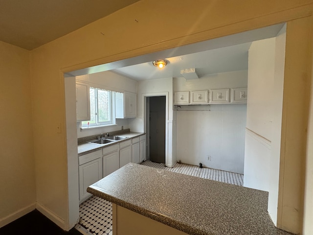 kitchen featuring a sink and white cabinetry