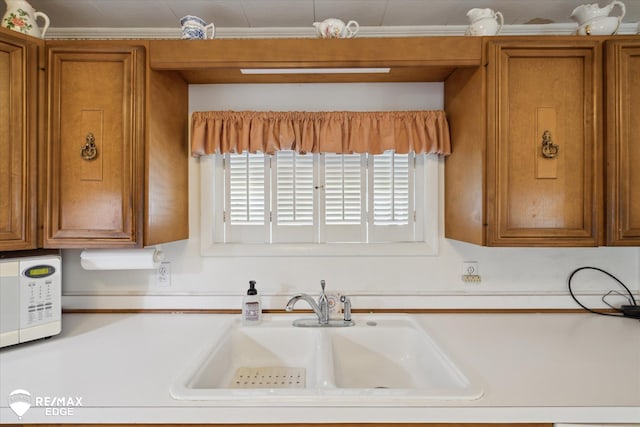 7309 N Genesee Rd, Genesee, MI 48437 - kitchen with brown cabinets, light countertops, a sink, and white microwave