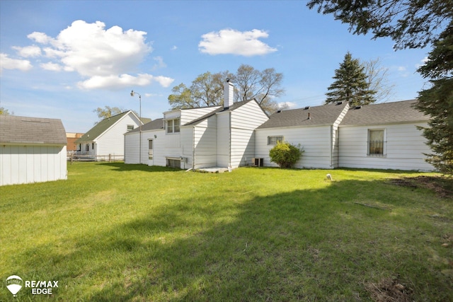 7309 N Genesee Rd, Genesee, MI 48437 - rear view of house with fence, a yard, a chimney, and cooling unit