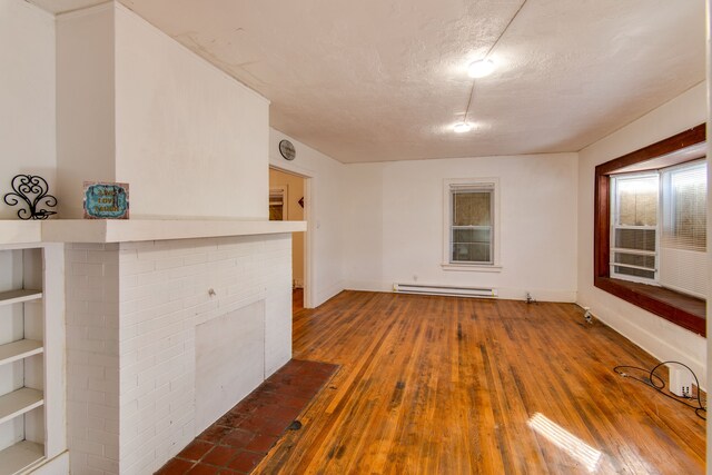 1636 N Grand Traverse St, Flint, MI 48503 - empty room with baseboards, a baseboard radiator, wood-type flooring, and a textured ceiling