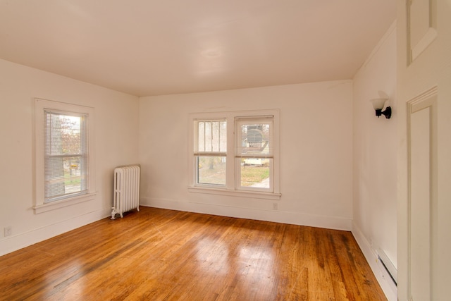 1636 N Grand Traverse St, Flint, MI 48503 - empty room featuring radiator, baseboards, a baseboard heating unit, and light wood-style flooring
