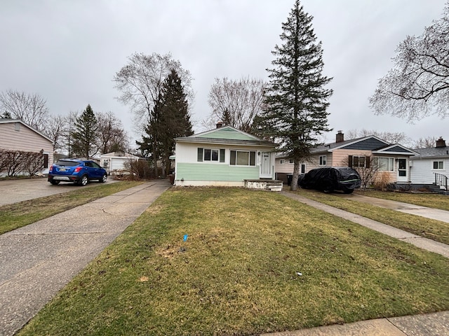 bungalow-style house featuring a front lawn, entry steps, and concrete driveway
