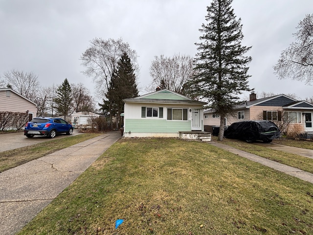 bungalow-style house with driveway and a front yard