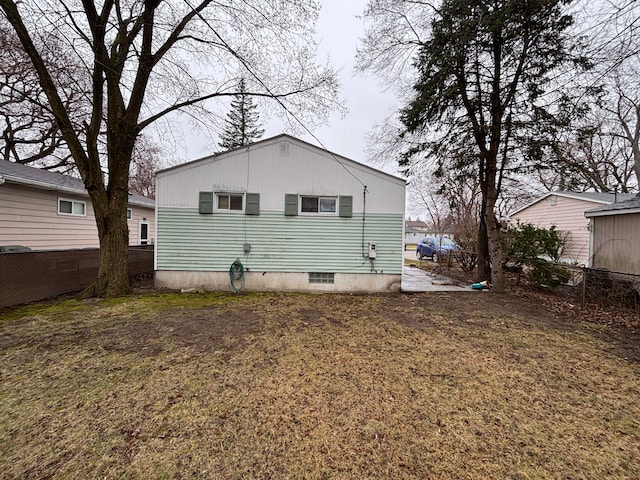 back of property featuring a yard and fence
