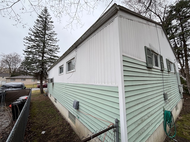 view of side of home featuring fence