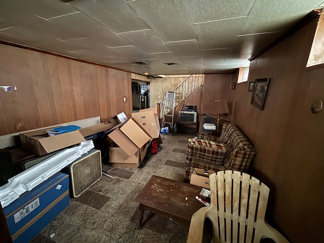 below grade area with stairs, tile patterned floors, and wooden walls