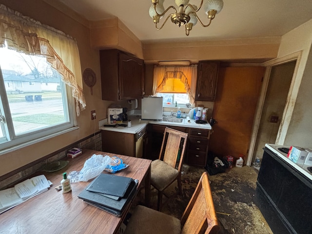 kitchen featuring light countertops, plenty of natural light, dark brown cabinets, and a chandelier