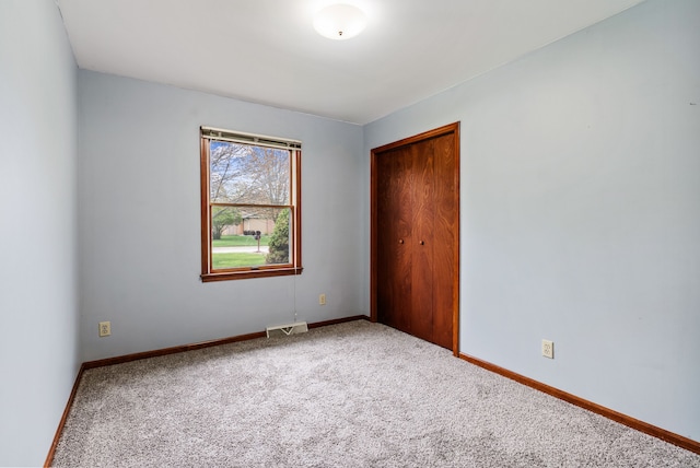 unfurnished bedroom with a closet, visible vents, baseboards, and carpet floors