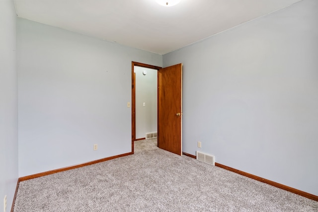 carpeted empty room with visible vents and baseboards