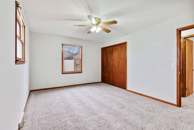 unfurnished bedroom with carpet flooring, a closet, baseboards, and a ceiling fan