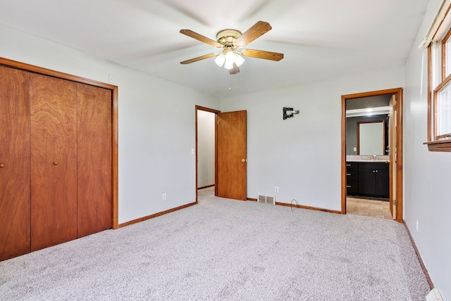 unfurnished bedroom featuring light colored carpet, a closet, visible vents, and baseboards
