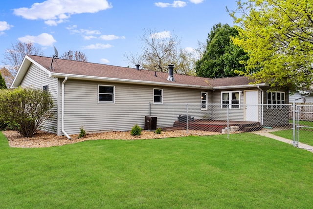 rear view of house featuring a yard, roof with shingles, fence, and a gate