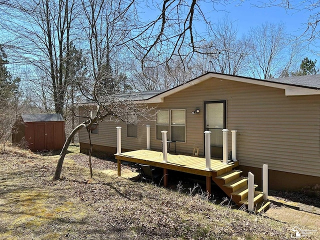 rear view of house featuring a shed, an outdoor structure, and a deck