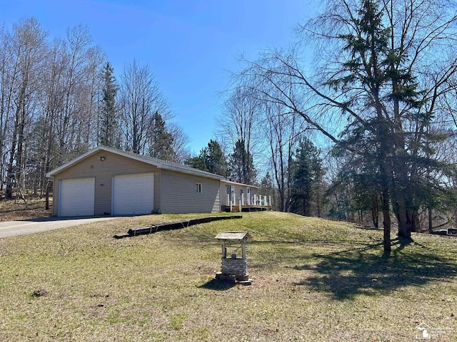 view of side of property with a lawn, an outbuilding, and a detached garage
