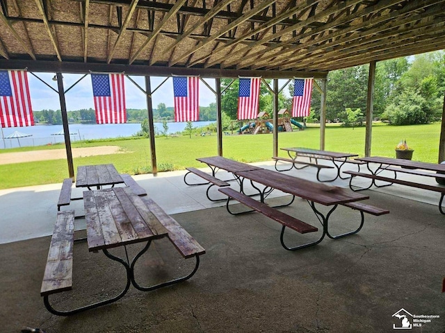 surrounding community with a lawn, a water view, a patio, and a playground