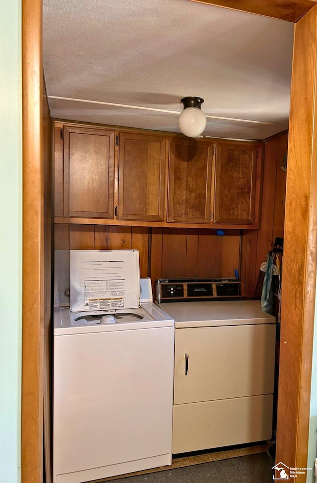 laundry room featuring washing machine and clothes dryer and cabinet space