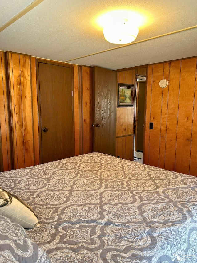 bedroom with two closets and wood walls