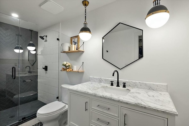 full bathroom featuring vanity, a shower stall, and toilet