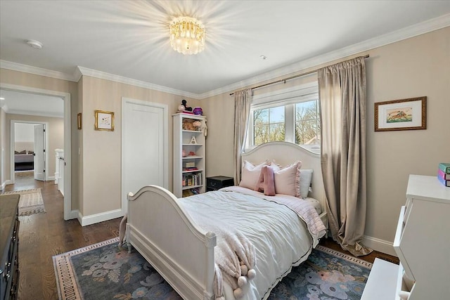 bedroom featuring baseboards, crown molding, wood finished floors, and a closet