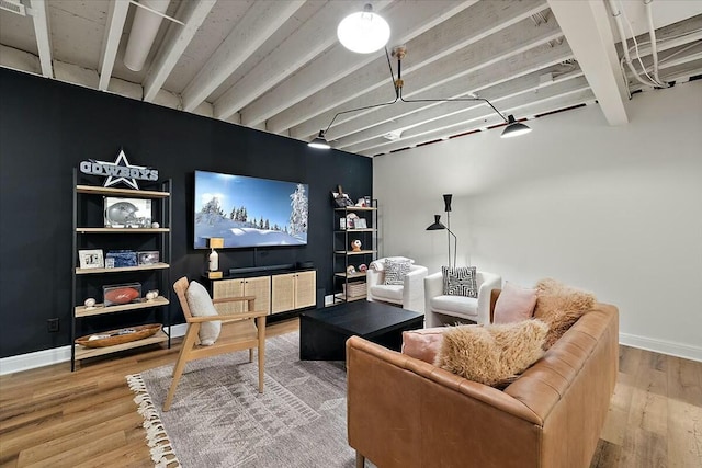 home theater room with baseboards, beam ceiling, and wood finished floors